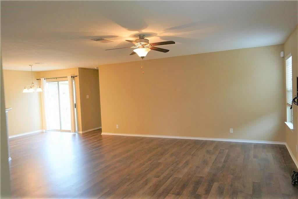 201 Edwin Kyle, TX 78640 - Photo 4 of 21 Spacious room featuring wood-finish flooring, a ceiling fan with integrated lighting, and neutral wall tones