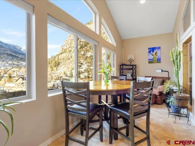 a view of a dining room with furniture large windows and wooden floor
