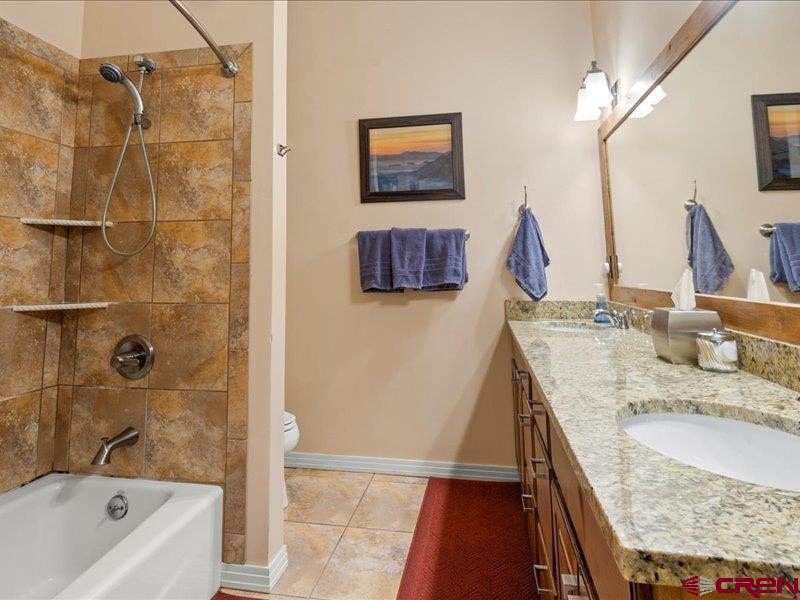 1271 Main Street Ouray, CO 81427 - Photo 29 of 45 a bathroom with a granite countertop sink a mirror and shower