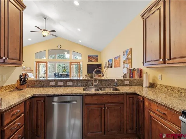a kitchen with granite countertop a sink stainless steel appliances and cabinets