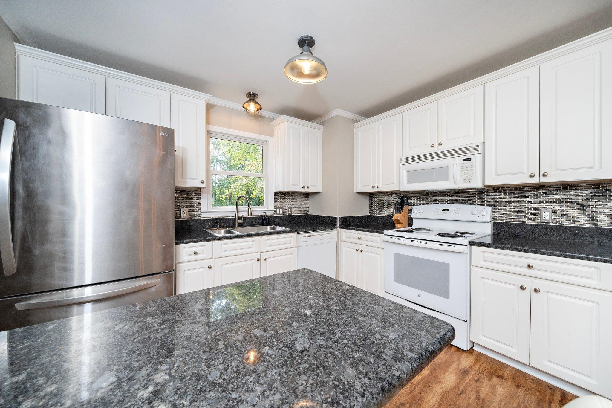 4400 Liverpool Lane Raleigh, NC 27604 - Photo 22 of 34 a kitchen with granite countertop white cabinets and white stainless steel appliances