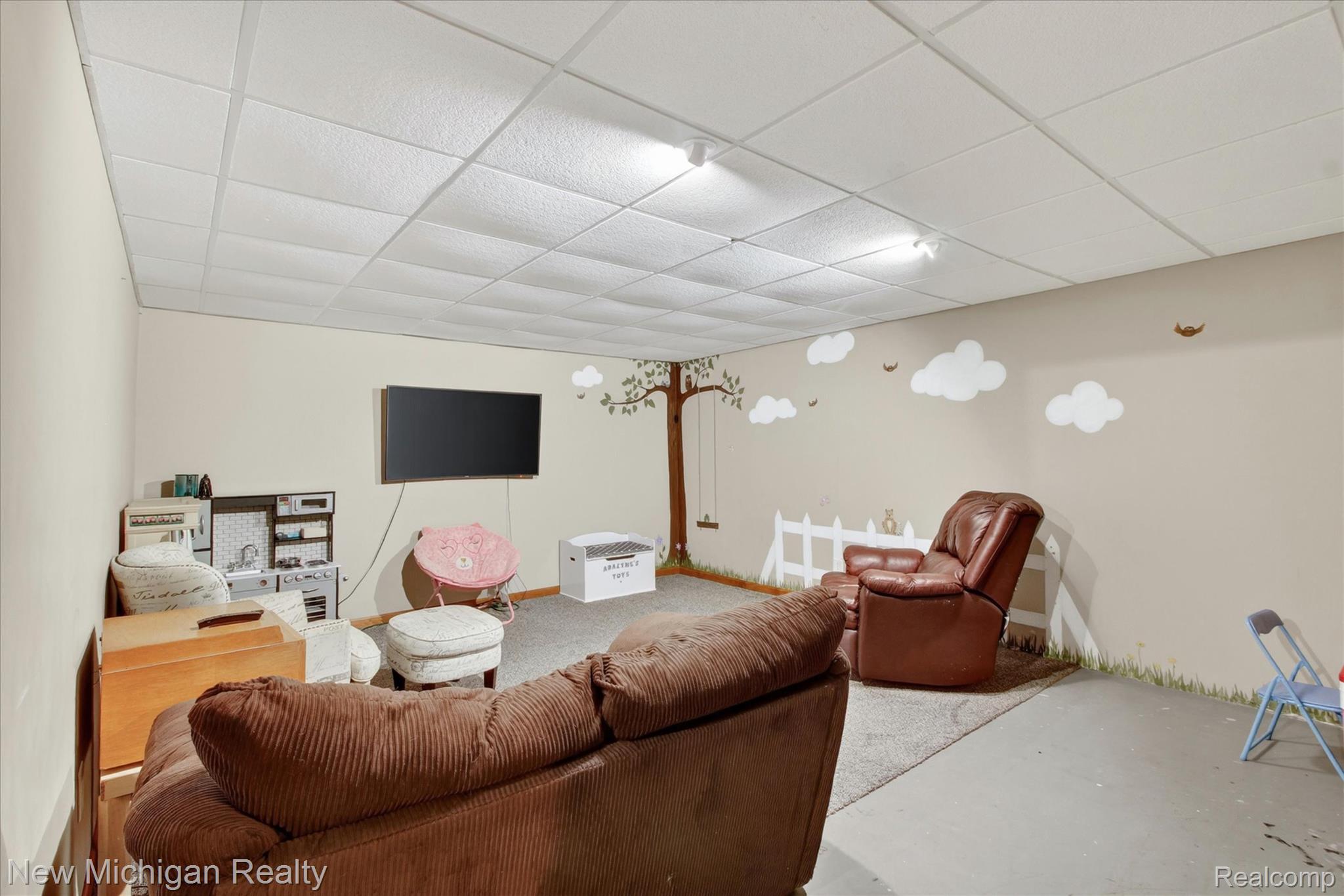 22623 11 Mile Road Reed City, MI 49677 - Photo 34 of 47 Finished room featuring light-toned walls, a drop ceiling with integrated lighting, and a wall-mounted display