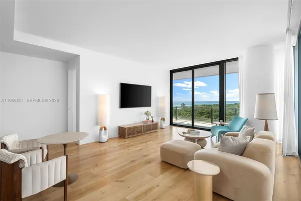 a living room with furniture and a large window with balcony view