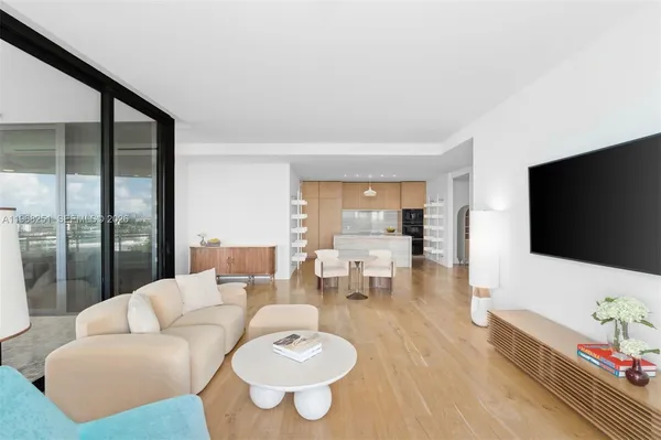 a large white kitchen with a sink and dishwasher a refrigerator with wooden floor