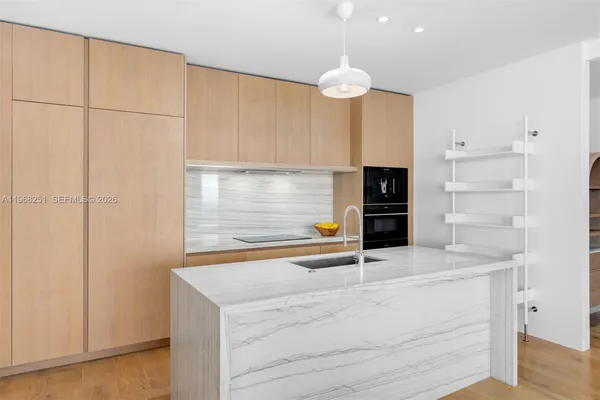 a kitchen with granite countertop white cabinets and stainless steel appliances