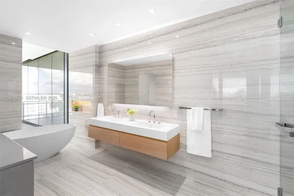 a spacious bathroom with a double vanity sink a mirror and a bathtub