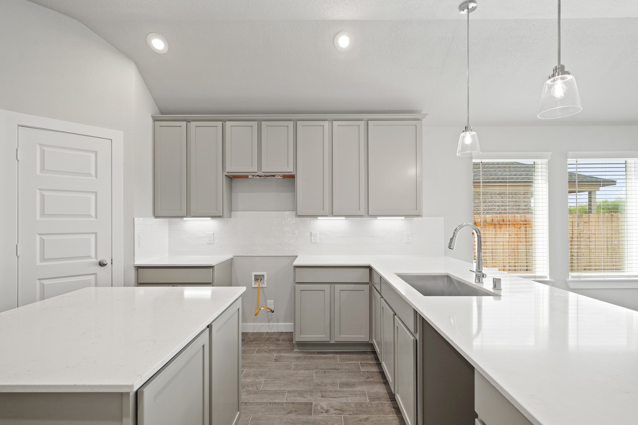 3106 Boulder Ridge Drive Rosenberg, TX 77471 - Photo 3 of 34 a kitchen with a sink dishwasher and white cabinets with wooden floor