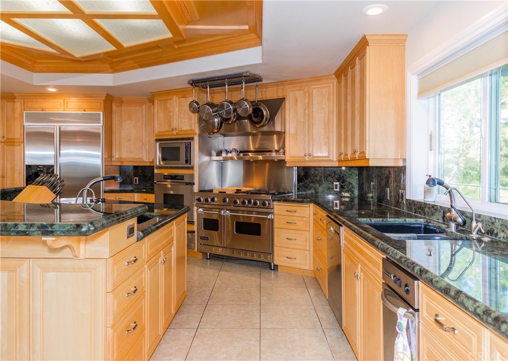 22595 Adobe Road Red Bluff, CA 96080 - Photo 37 of 71 a kitchen with stainless steel appliances granite countertop a stove a sink and a microwave