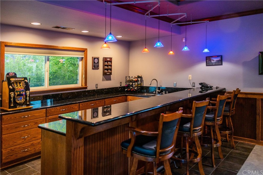 22595 Adobe Road Red Bluff, CA 96080 - Photo 49 of 71 a kitchen with stainless steel appliances kitchen island granite countertop a table chairs in it and wooden floor