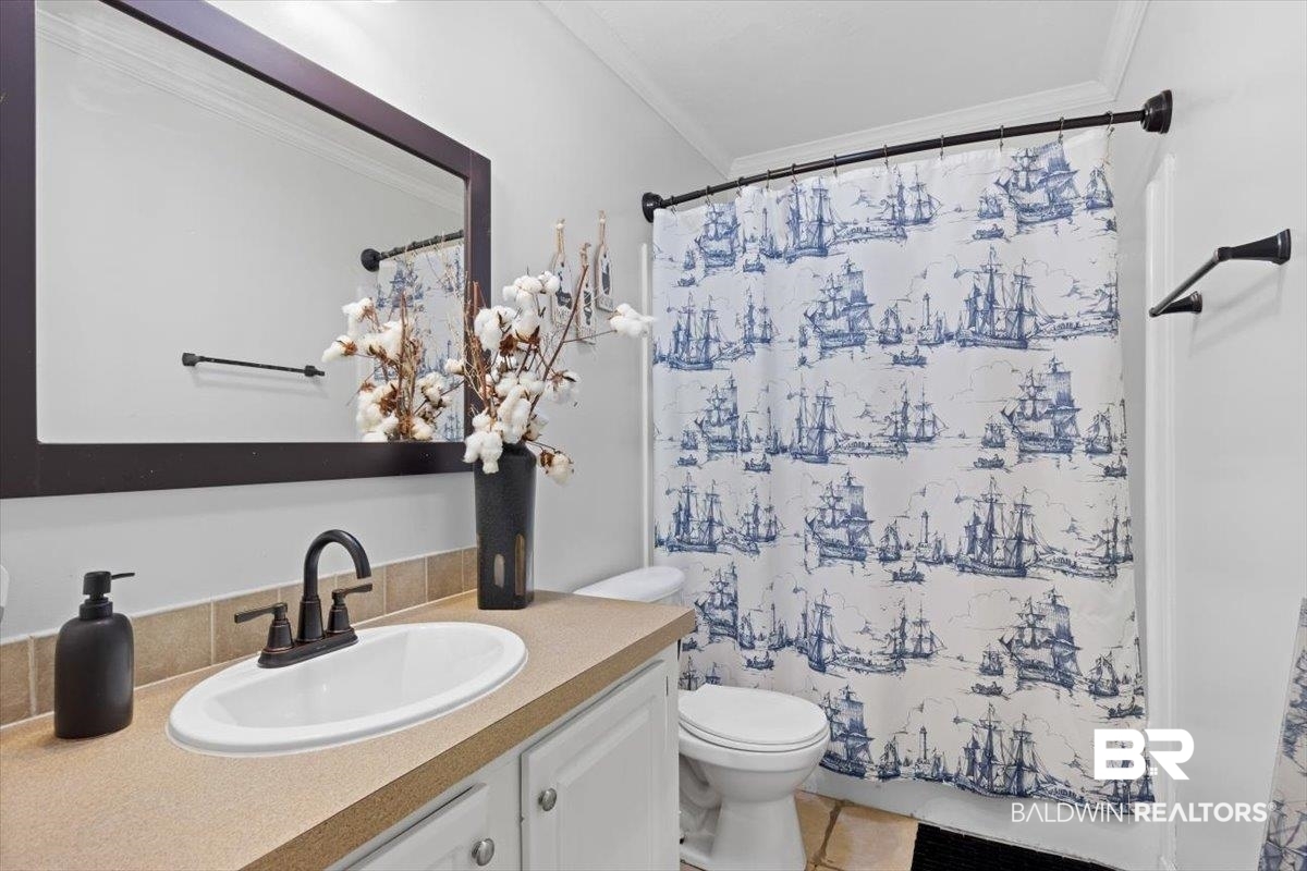 6971 March Road Theodore, AL 36582 - Photo 11 of 26 Full bathroom featuring a shower with curtain, crown molding, toilet, and vanity
