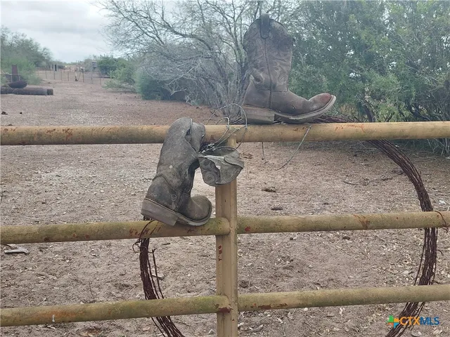 a view of a yard with wooden fence