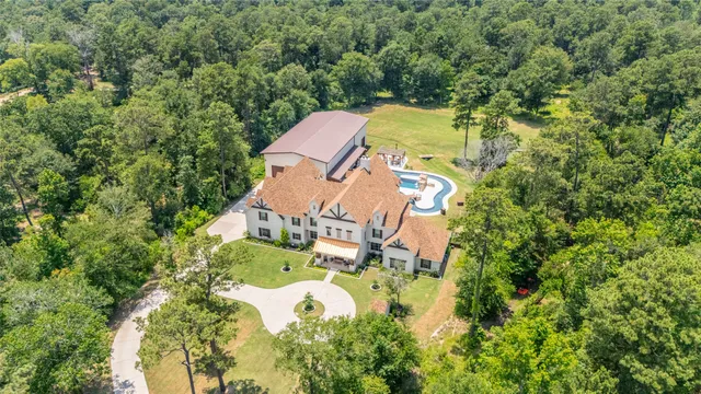 an aerial view of a house with swimming pool and garden space