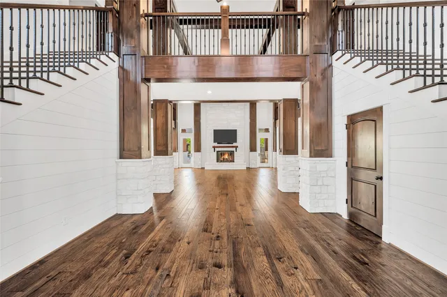a view of a living room with wooden floor and fireplace