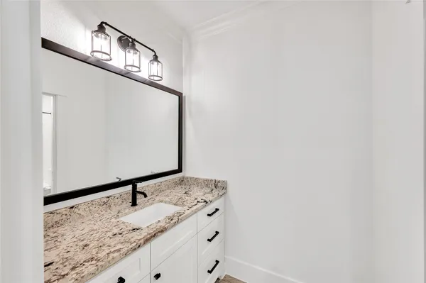 a bathroom with a granite countertop sink and a mirror