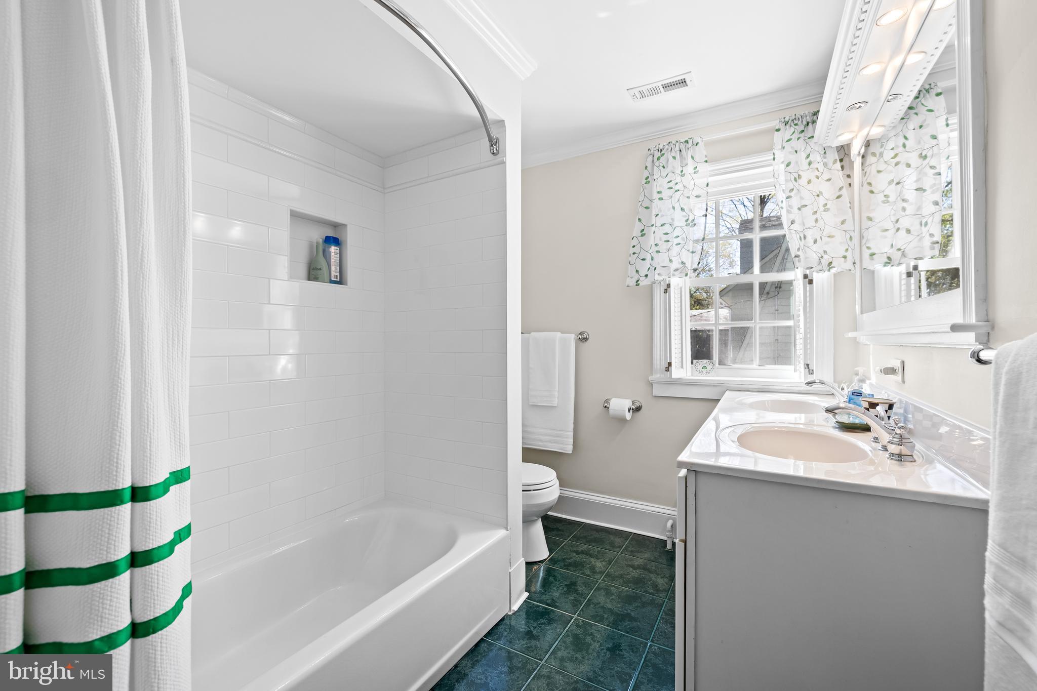 4309 Wendover Road Baltimore, MD 21218 - Photo 43 of 56 a bathroom with a sink a bathtub and a window