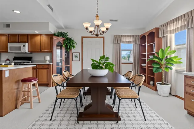 a dining room filled chandelier and wooden floor