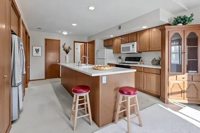 a kitchen with stainless steel appliances granite countertop a refrigerator and a stove top oven