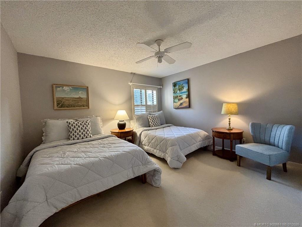 5152 Southeast Club Way, Unit 104 Stuart, FL 34997 - Photo 12 of 28 a bedroom with two beds and a couch