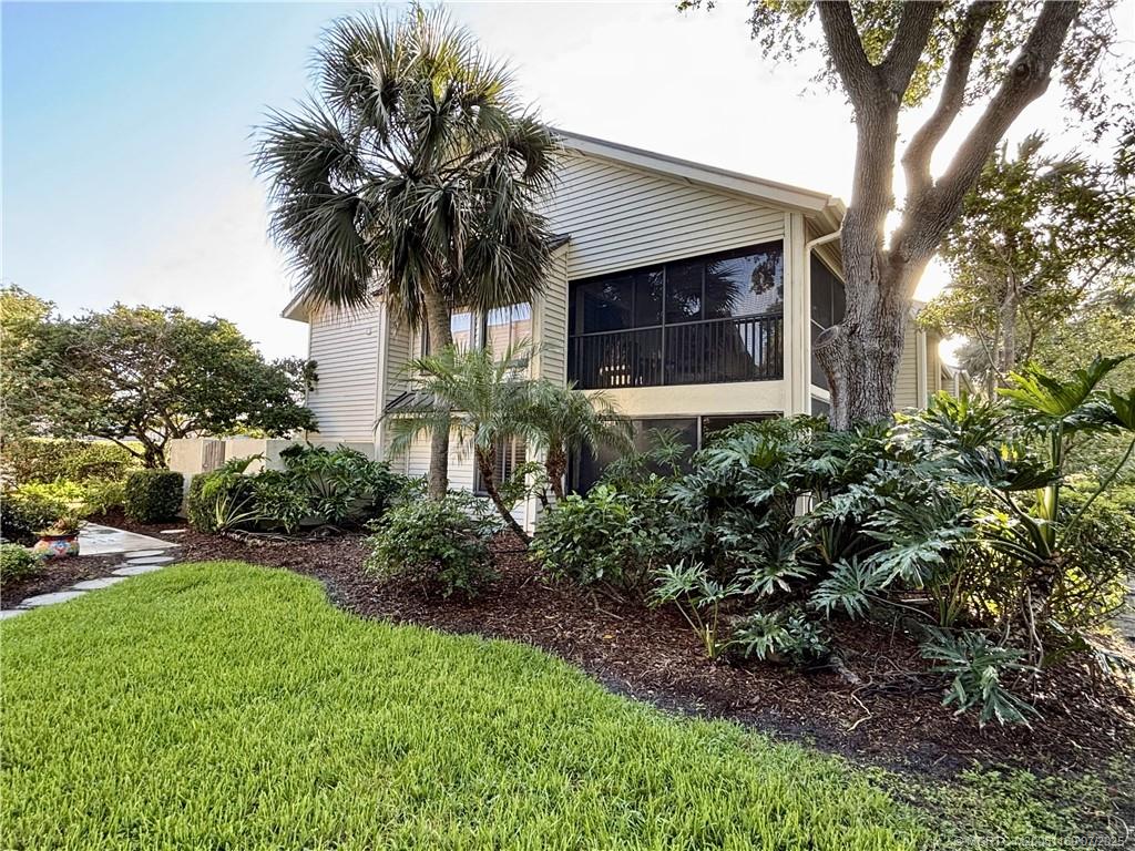 5152 Southeast Club Way, Unit 104 Stuart, FL 34997 - Photo 20 of 28 a front view of a house with a yard and garage