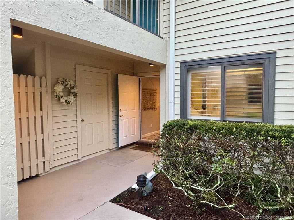 5152 Southeast Club Way, Unit 104 Stuart, FL 34997 - Photo 2 of 28 a view of a house with a large window and potted plants