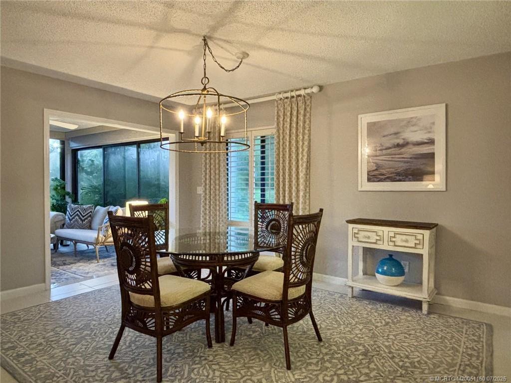 5152 Southeast Club Way, Unit 104 Stuart, FL 34997 - Photo 5 of 28 a view of a dining room with furniture and a chandelier