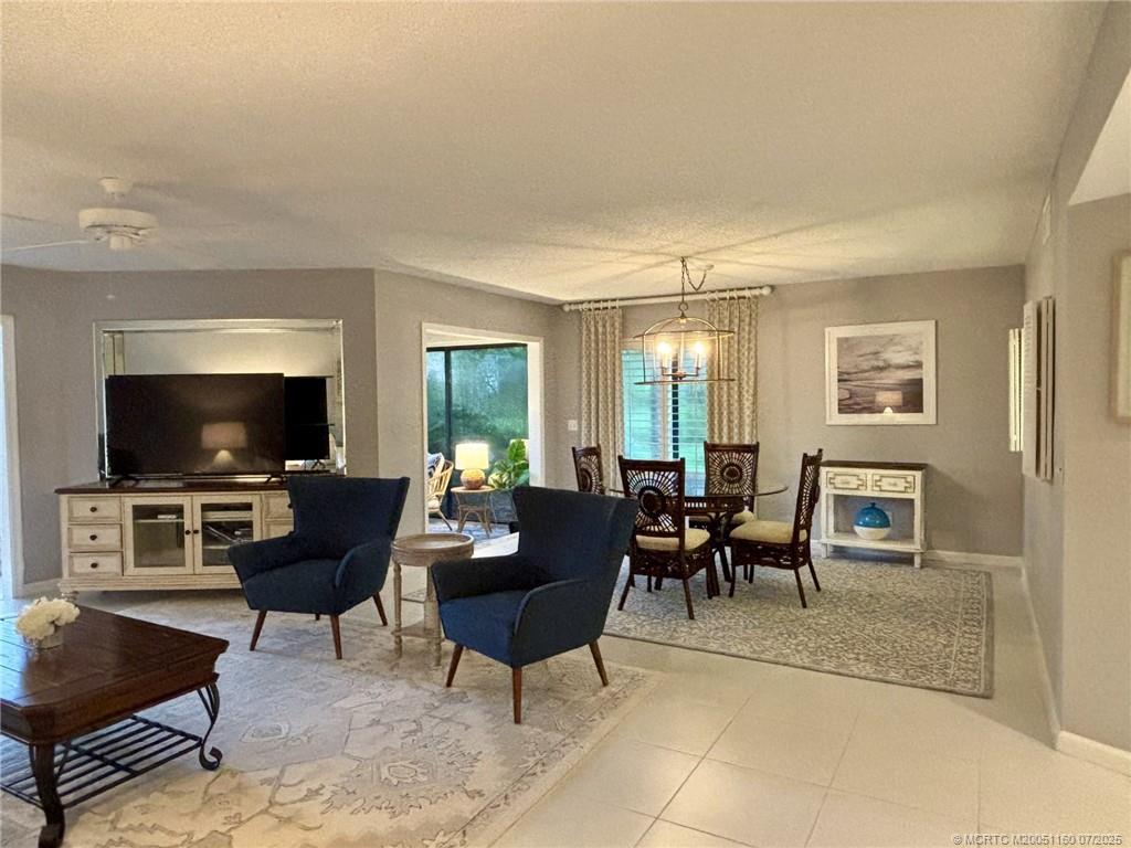 5152 Southeast Club Way, Unit 104 Stuart, FL 34997 - Photo 6 of 28 a living room with furniture a flat screen tv and a window