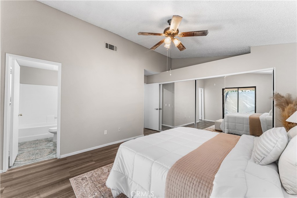 3542 East Ave R 10 Palmdale, CA 93550 - Photo 19 of 35 a bedroom with a large bed chandelier and a window