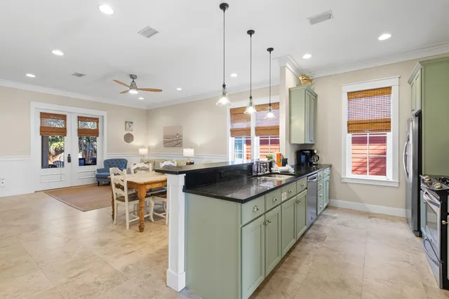 a kitchen with stainless steel appliances granite countertop a stove a sink a refrigerator and chairs