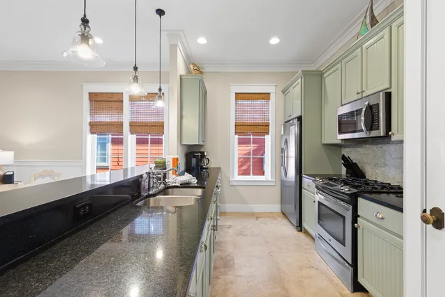 a large kitchen with kitchen island granite countertop a large window and stainless steel appliances