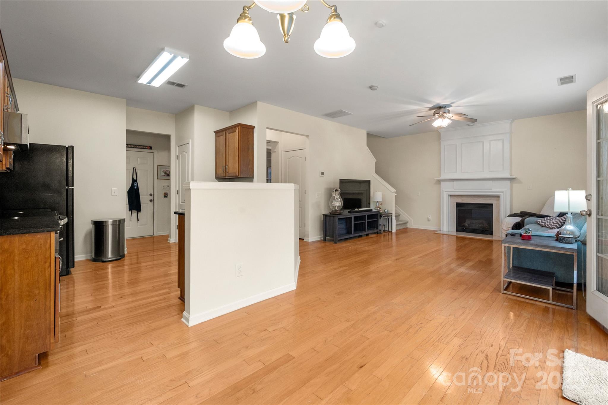 2223 Blueberry Ridge Road Matthews, NC 28105 - Photo 11 of 25 a view of a livingroom with furniture a ceiling fan a refrigerator and a fireplace