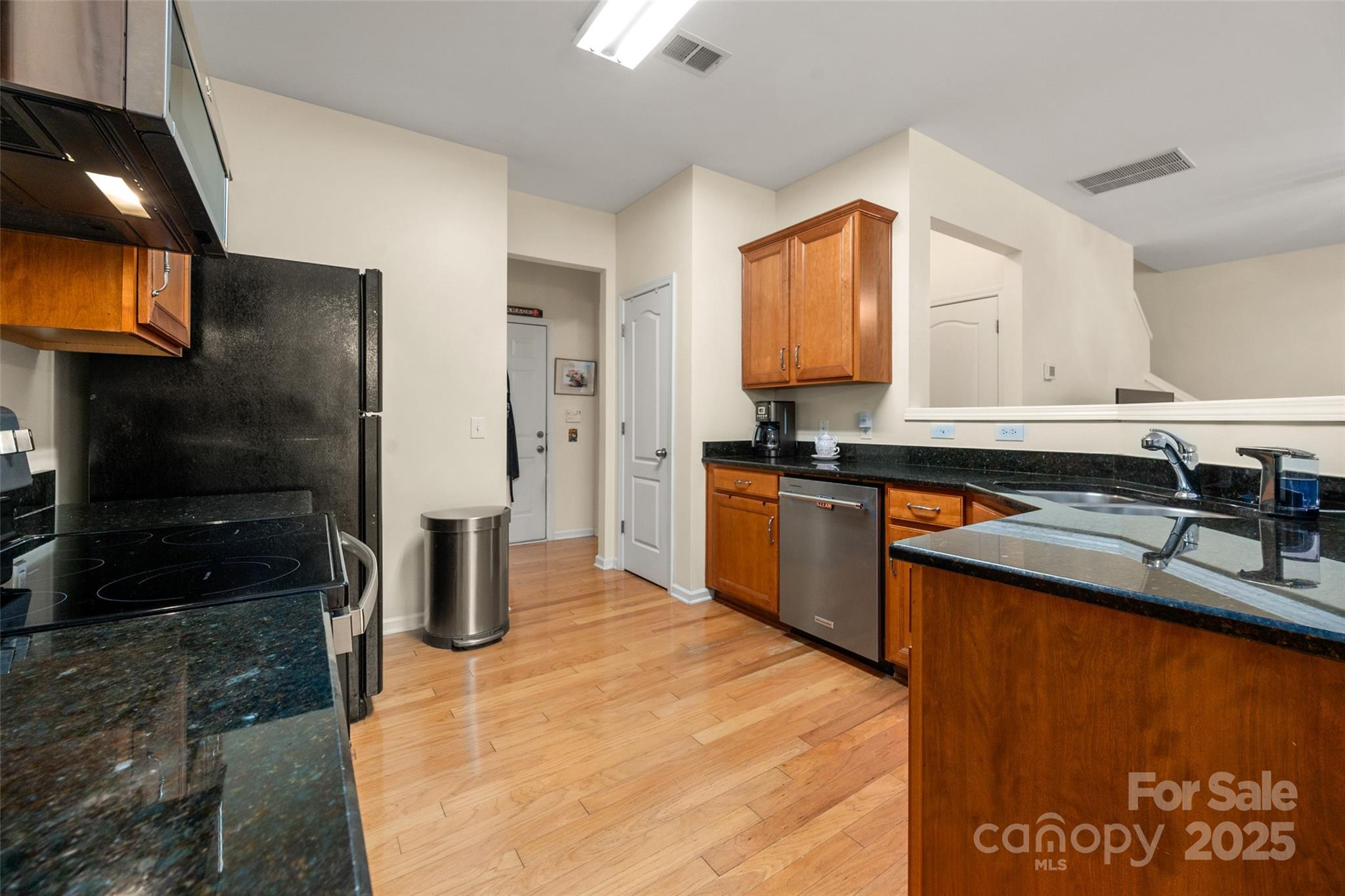 2223 Blueberry Ridge Road Matthews, NC 28105 - Photo 12 of 25 a kitchen with stainless steel appliances granite countertop a sink a stove and a refrigerator