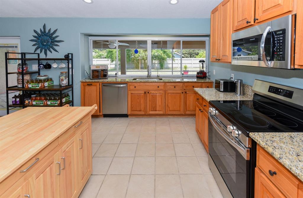 2962 Southeast Darien Road Port St. Lucie, FL 34952 - Photo 11 of 33 a kitchen with stainless steel appliances granite countertop a stove a sink and a microwave