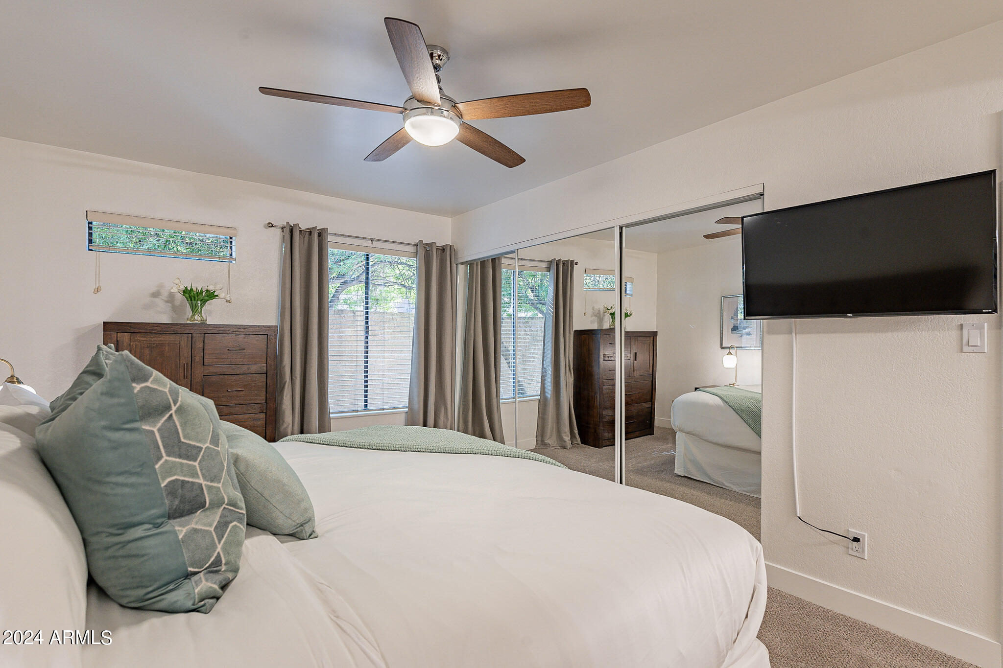 3500 North Hayden Road, Unit 1005 Scottsdale, AZ 85251 - Photo 25 of 51 a bedroom with a large bed and a flat screen tv