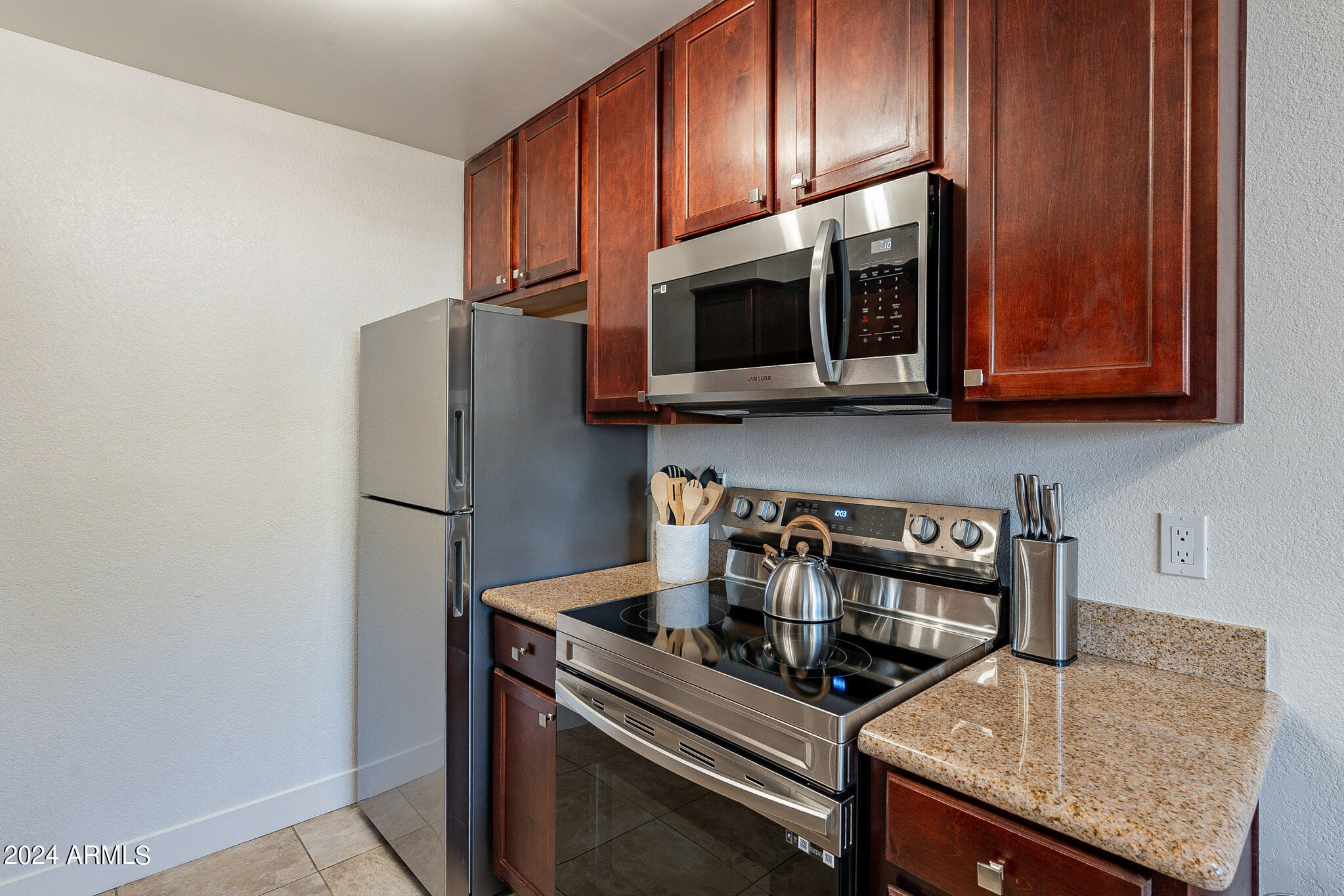 3500 North Hayden Road, Unit 1005 Scottsdale, AZ 85251 - Photo 8 of 51 a kitchen with stainless steel appliances granite countertop a refrigerator stove and microwave