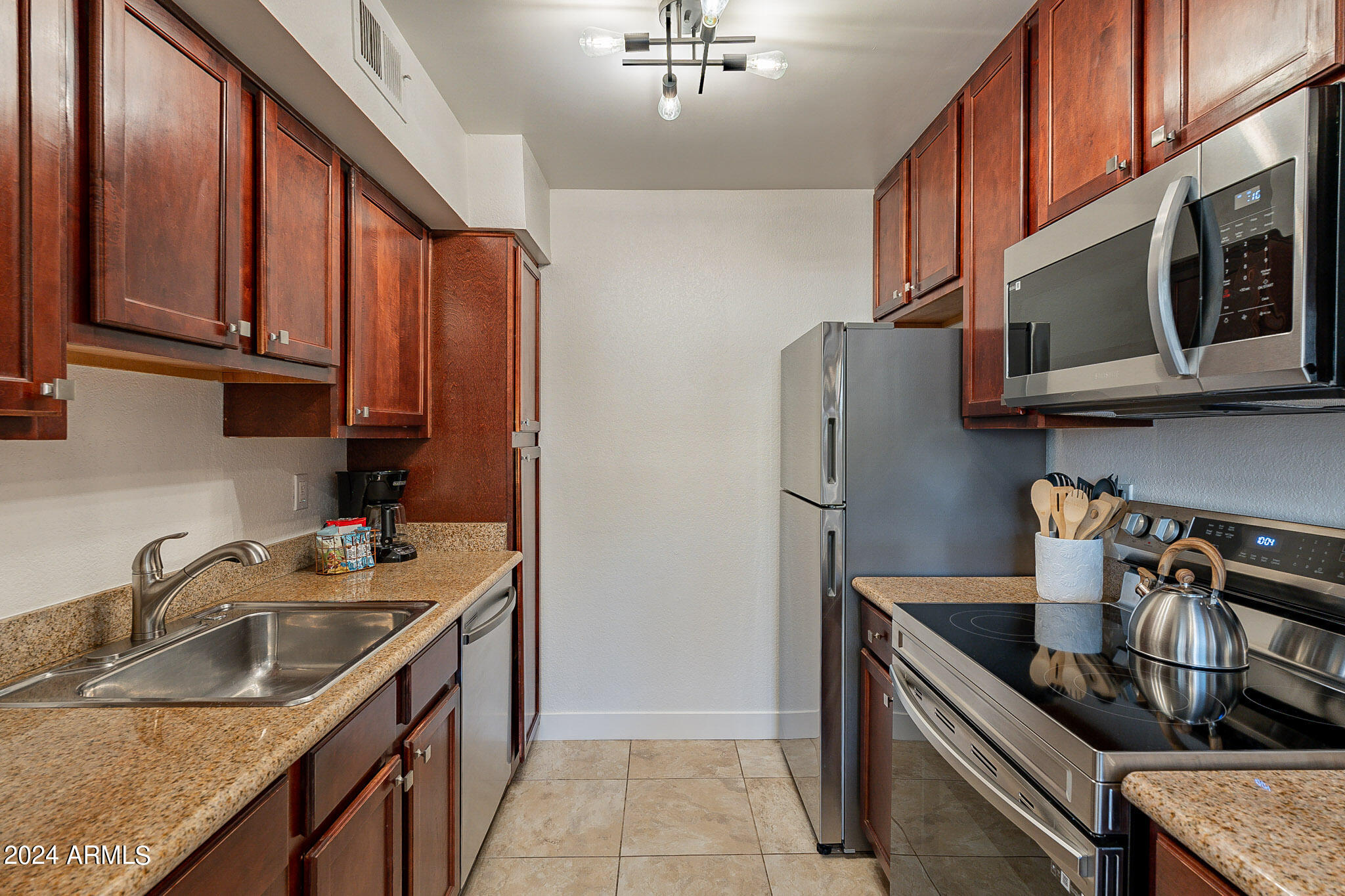 3500 North Hayden Road, Unit 1005 Scottsdale, AZ 85251 - Photo 9 of 51 a kitchen with stainless steel appliances granite countertop a sink stove and refrigerator