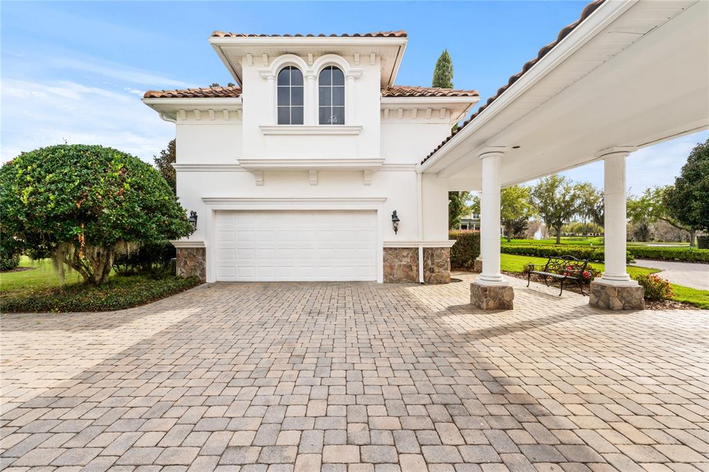9343 Tibet Pointe Circle Windermere, FL 34786 - Photo 12 of 100 a front view of a house with a yard and potted plants
