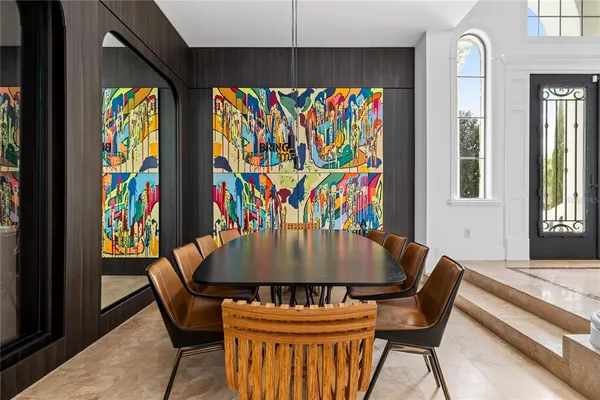 a dining room with furniture and a large window