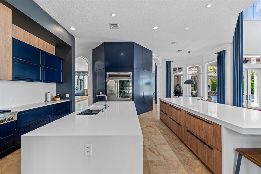 9343 Tibet Pointe Circle Windermere, FL 34786 - Photo 30 of 100 a large kitchen with kitchen island a large counter top space a sink stainless steel appliances and cabinets