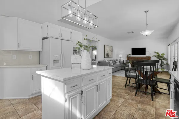 a kitchen with cabinets a sink dining table and chairs