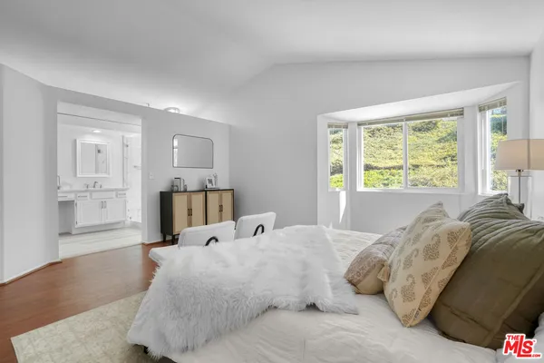 a bed sitting in a bedroom next to a window