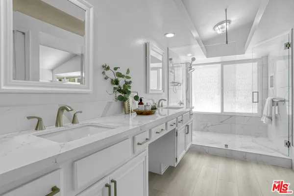 a bathroom with a granite countertop sink mirror and a bath tub