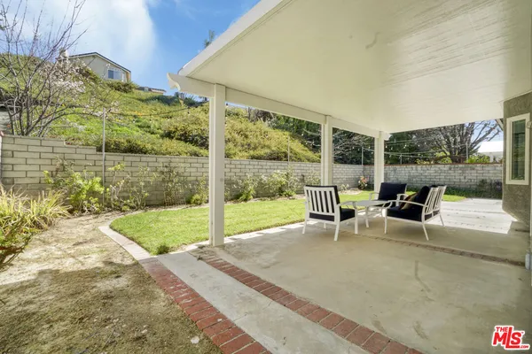 a view of a patio with a table chairs and garden