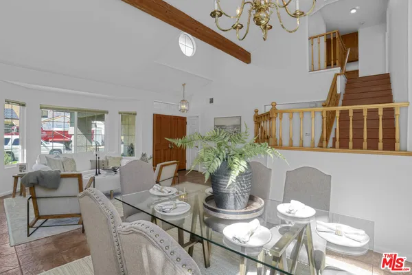 a dining room with furniture a kitchen and chandelier