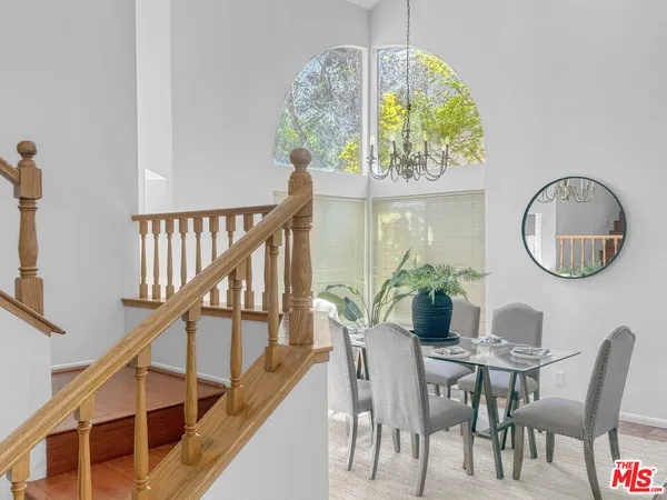 a view of a dining room with furniture a chandelier and wooden floor