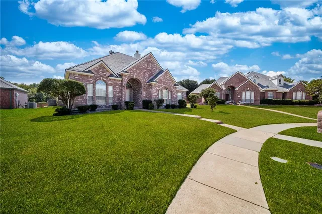 a view of a big house with a big yard and large trees
