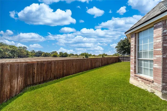 a view of a backyard with wooden fence