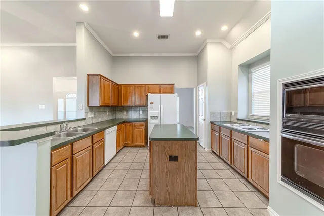 a kitchen with stainless steel appliances granite countertop a stove a sink and a refrigerator
