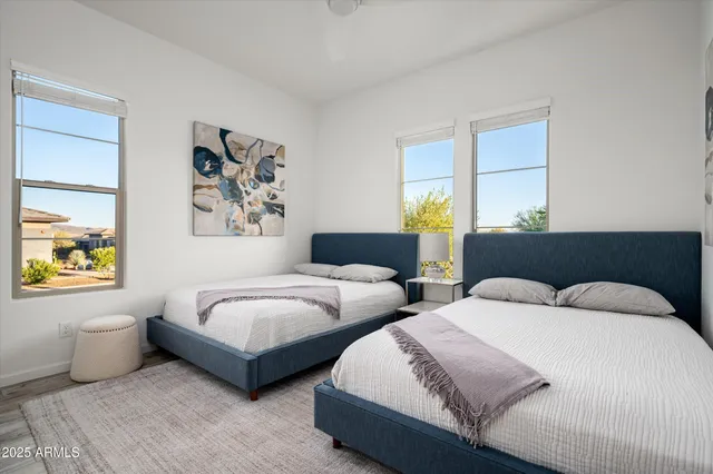 a bedroom with two beds and a large window