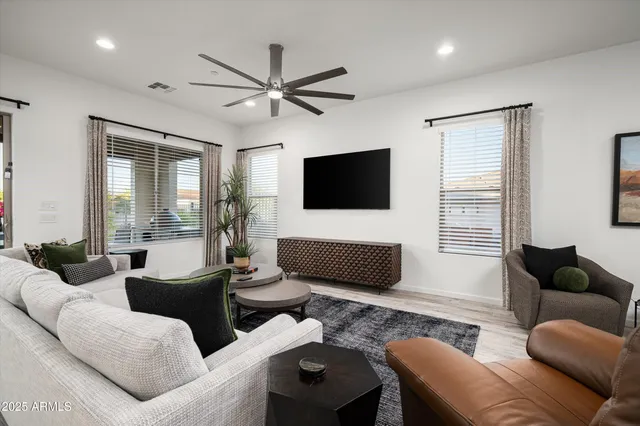 a living room with furniture a flat screen tv and a large window