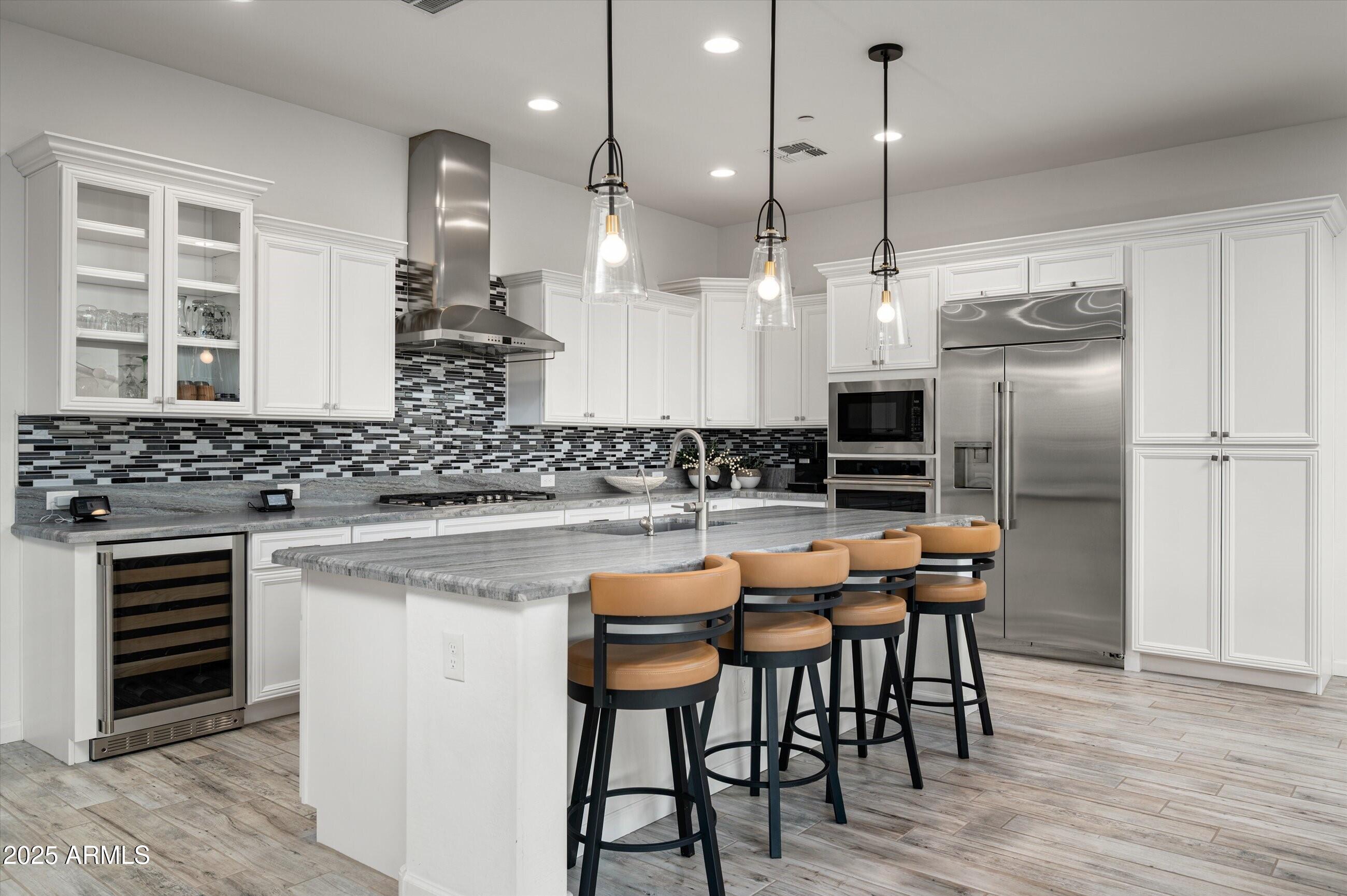 17864 East Veit Springs Drive Rio Verde, AZ 85263 - Photo 8 of 44 a kitchen with stainless steel appliances kitchen island granite countertop a stove a refrigerator and a wooden cabinets